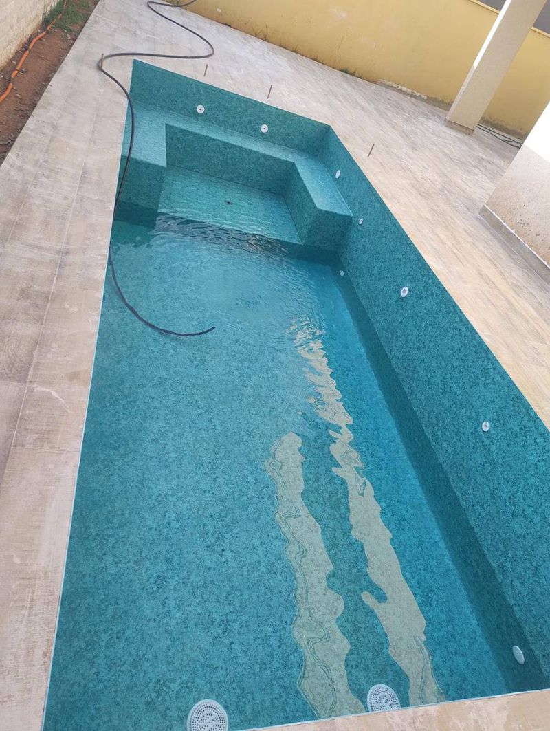 Piscina comprida com banco no fundo, estampa verde-azulada