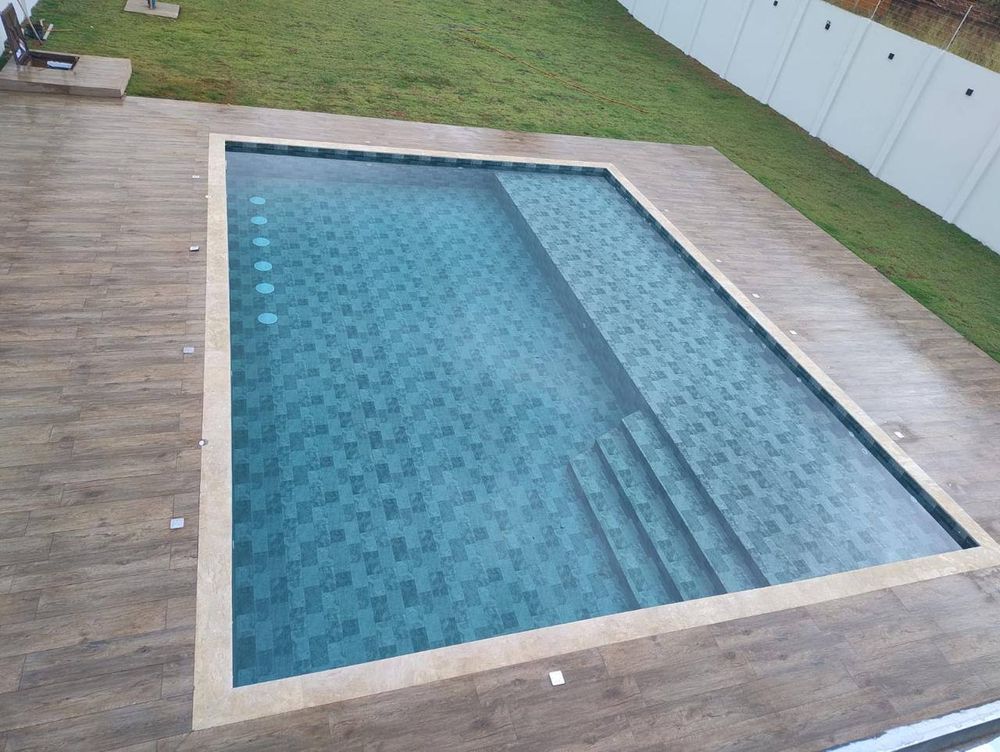 Piscina com degraus na lateral, com estampa de pedra cinza-azulada