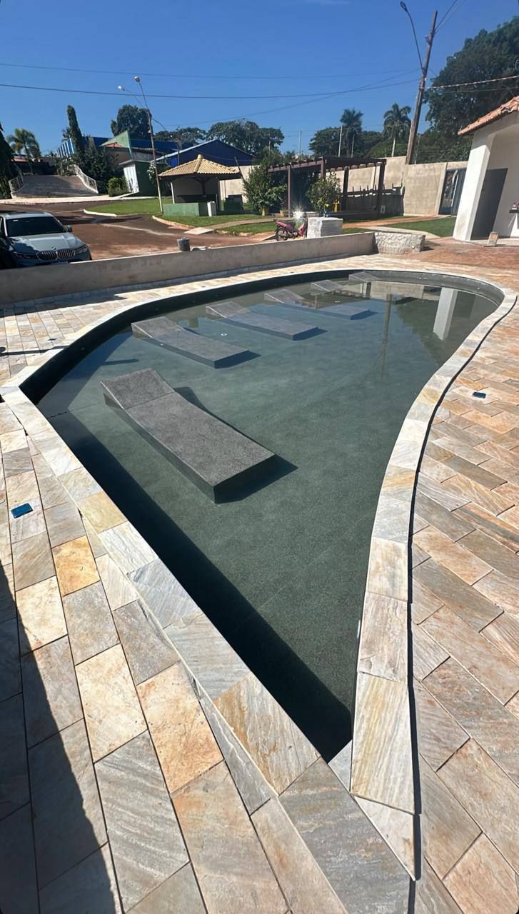 Piscina de formato triangular com bancos dentro da água, estampa escura